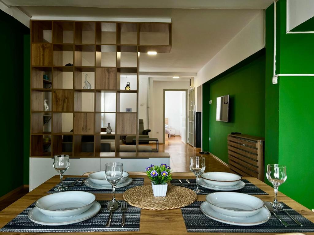 une salle à manger avec une table et un mur vert dans l'établissement Modern Flat in Prishtina Centre, à Pristina