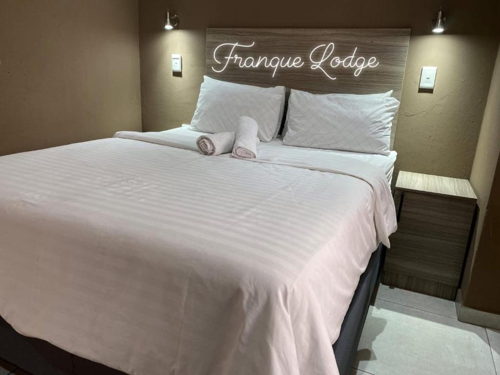Una cama blanca grande con dos toallas encima. en Franque Lodge, en Durban