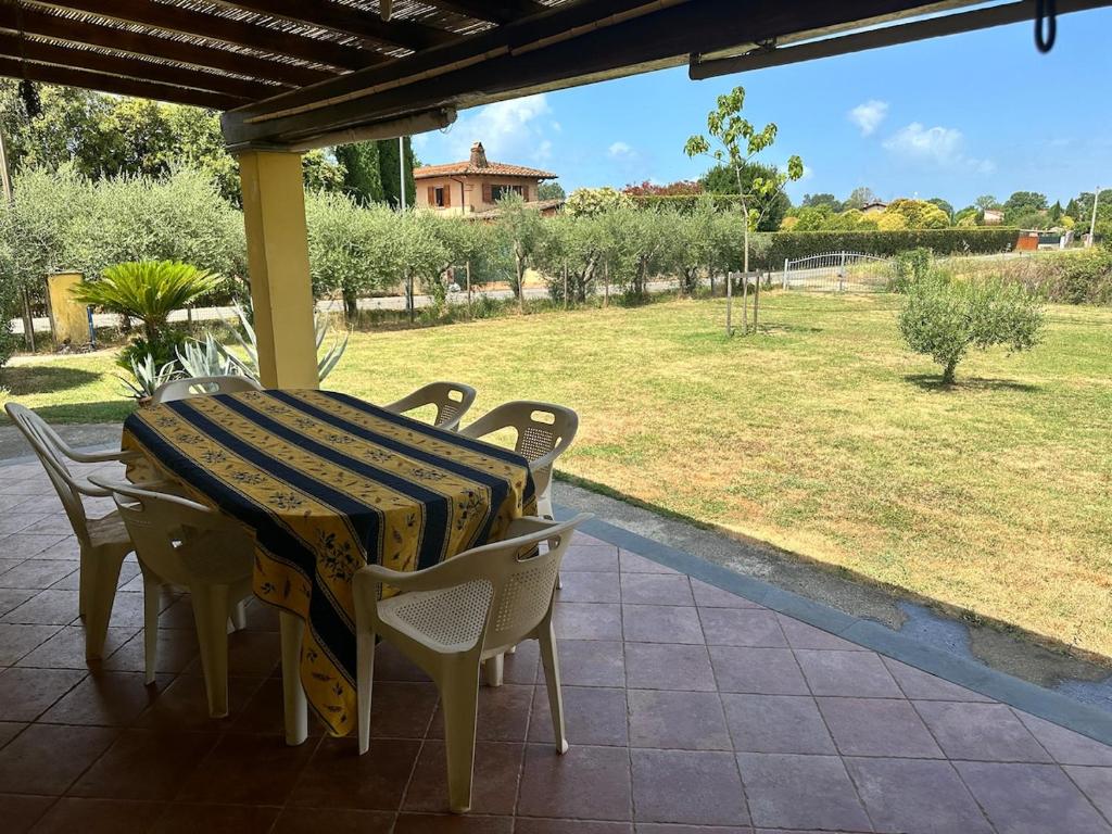 a table and chairs on a porch with a view of a field at La Paulonia Country House in Capezzano Pianore,