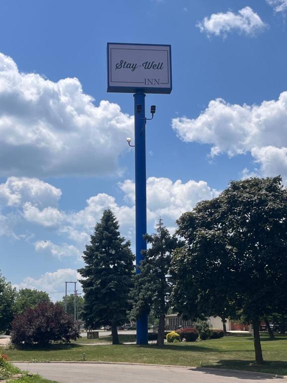 un cartel en un poste azul en un parque en Stay-Well Inn - Monroe, en Monroe