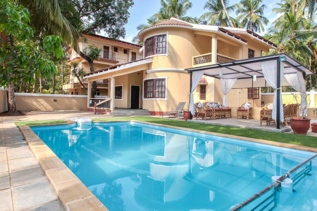 a house with a swimming pool in front of a house at Villa Calangute Phase 3 in Calangute