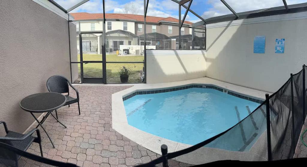- une piscine dans un bâtiment avec une table et des chaises dans l'établissement Charming 3BR Resort Townhome with Private Pool near Disney, à Kissimmee