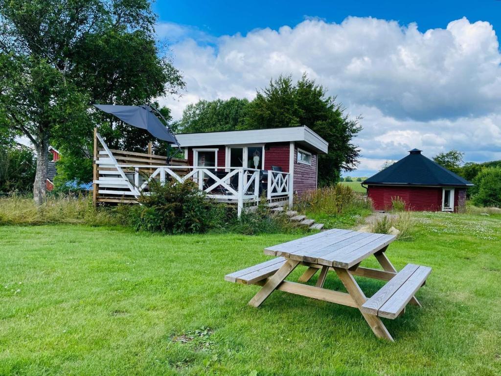 a picnic table in front of a cabin at 4 star holiday home in HÖRBY in Hörby