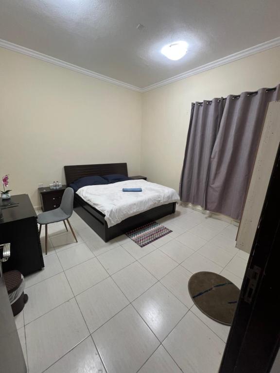 a bedroom with a bed and a table and a chair at Room for rent daily and monthly in Ajman 