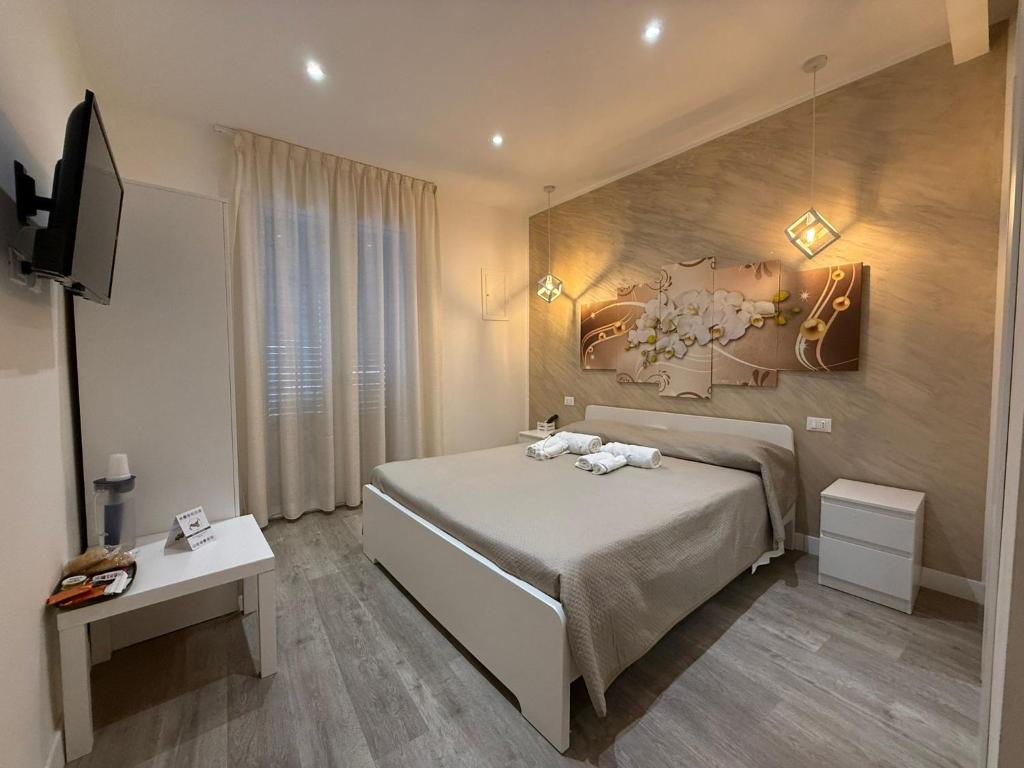 Un dormitorio con una cama con un cuadro en la pared. en ABT L'AURA, en Palermo