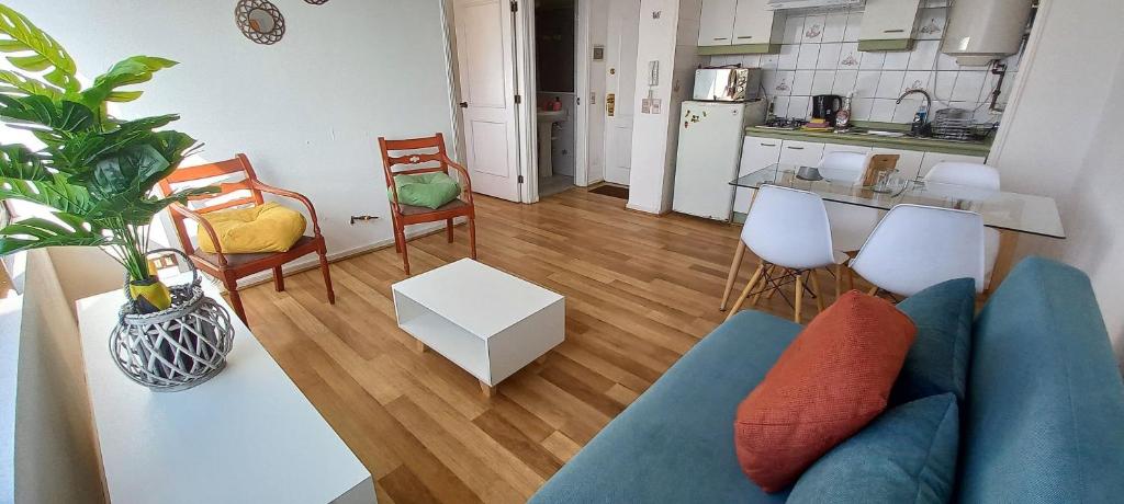 a living room with a blue couch and a kitchen at Rbkº Acogedor depto cercano a Playa Amarilla in Concón