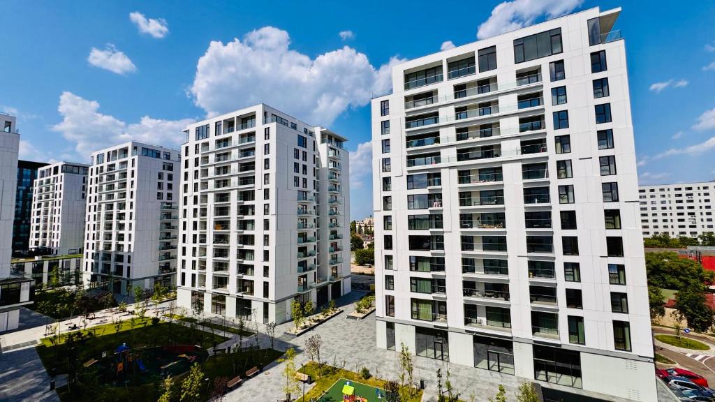 Your Home in Bucharest - Premium 1BR Apartments in ONE Cotroceni في بوخارست: مبنيان بيض طويلان في مدينة