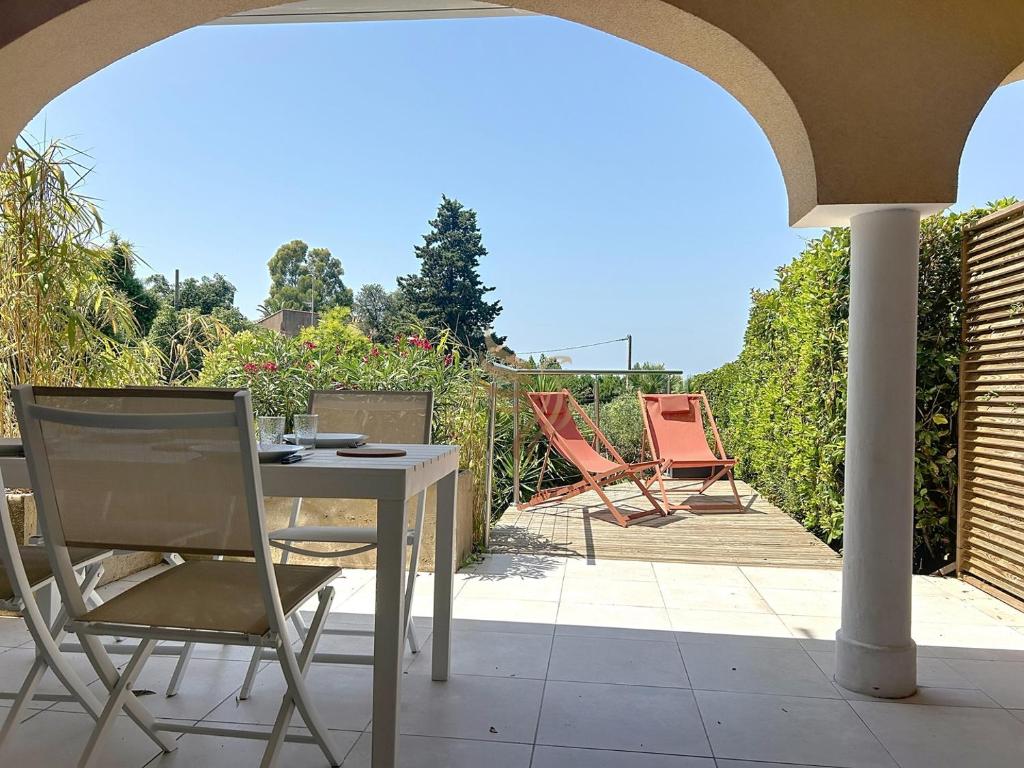 une table et des chaises assises sur une terrasse dans l'établissement 5-room studio - sea view- terrace - parking, à Saint-Raphaël