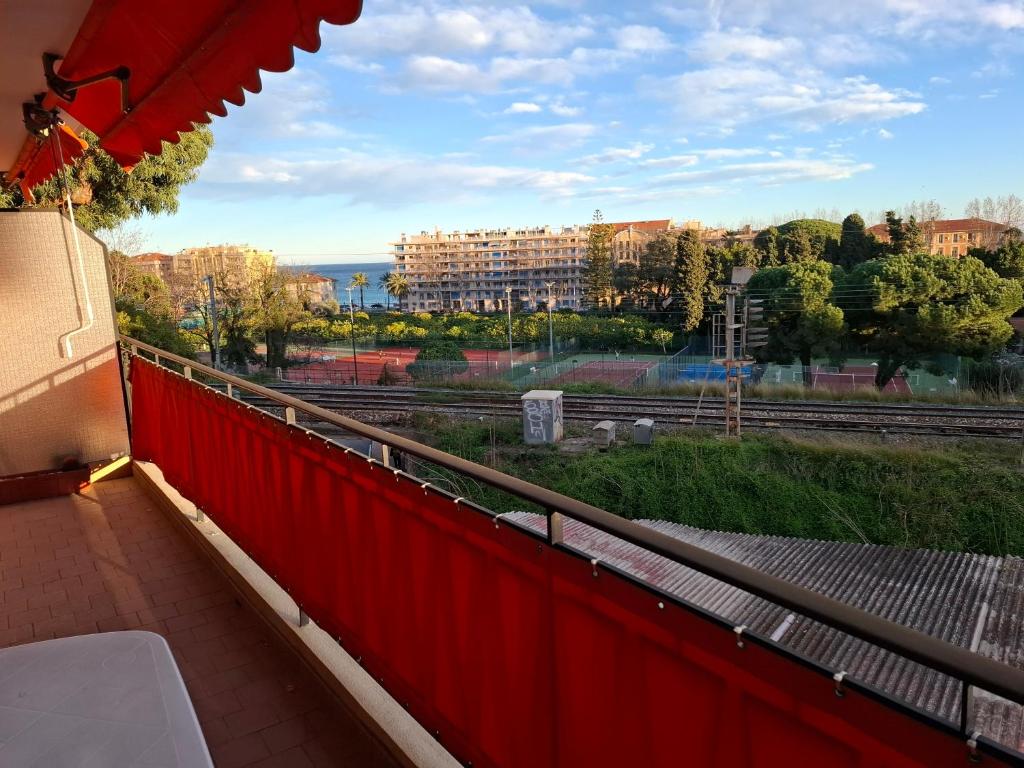 a red balcony with a view of a building at Appartement exposé plein sud in Menton