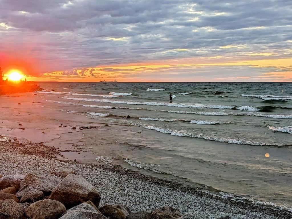 a beach with rocks and the ocean at sunset at Mariner motor hotel in Collingwood