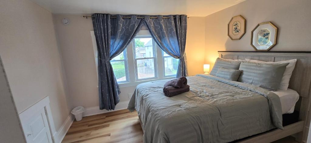 una camera da letto con un letto grande con una finestra di Kenmore Avenue Niagara Buffalo New York 3-Bedroom entire home a Kenmore