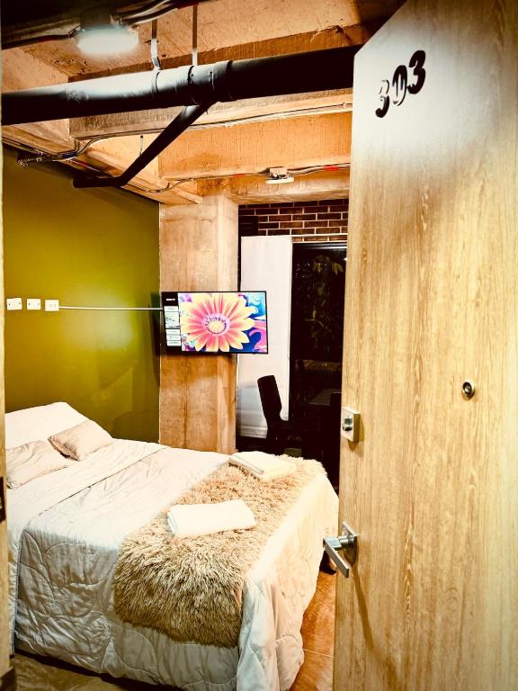 a bedroom with a bed and a flat screen tv at Beautiful loft with elevator for nomad envigado in Envigado