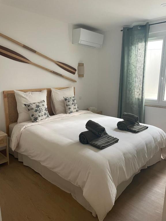une chambre avec un grand lit blanc avec des serviettes dessus dans l'établissement Villa Palmeira- Sainte-Maxime, à Sainte-Maxime