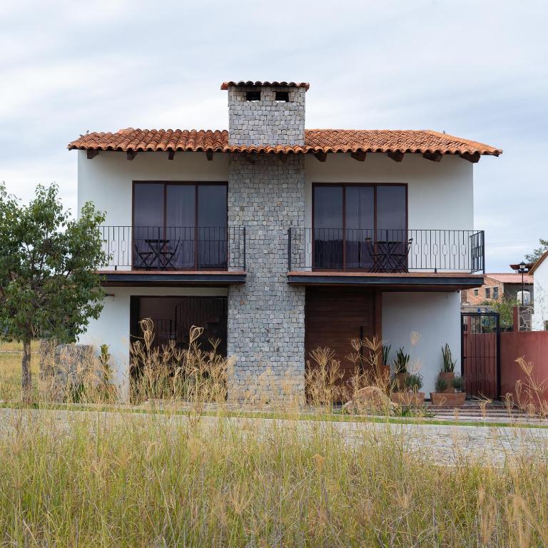 a house with a brick chimney and windows at Casa Xanu in Tapalpa