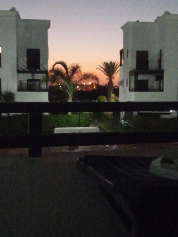 a view from a balcony of two buildings at sunset at Saidia Marina ap7 les Jardins de la Medina in Cherarba