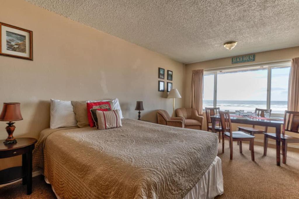 a hotel room with a bed and a table and chairs at Comfy Second Floor Beachfront Condo - Sleeps 4 - Pool and Sauna in Lincoln City