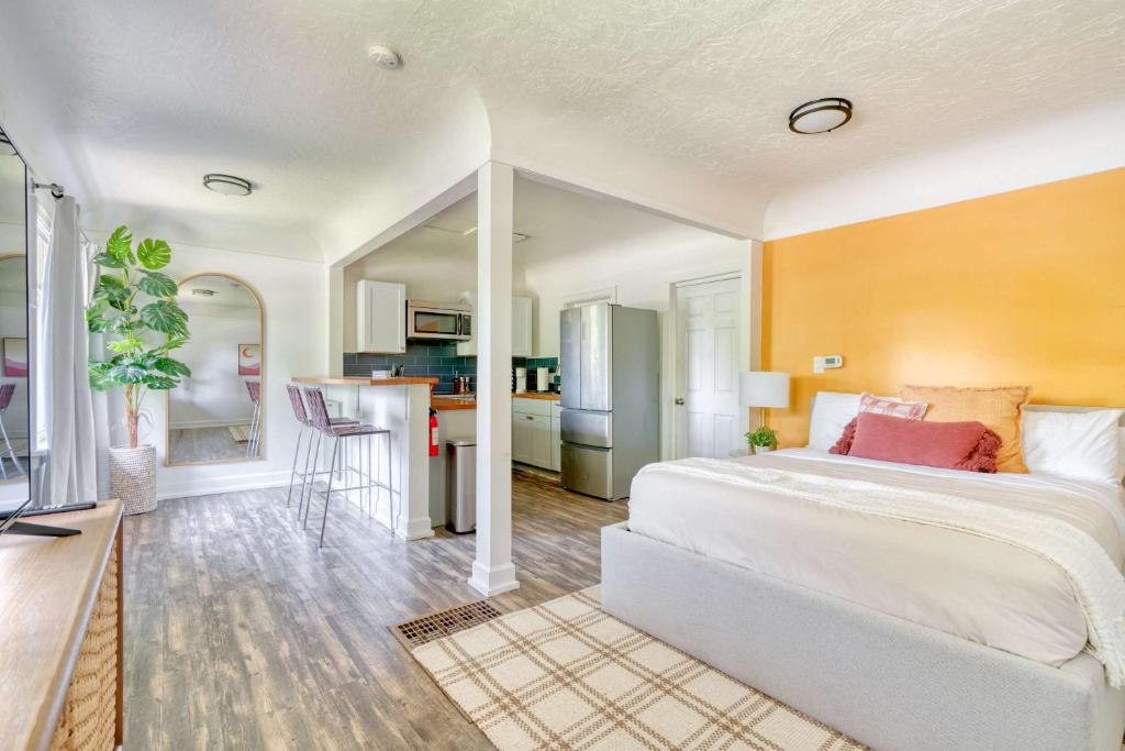 a bedroom with a large white bed and a kitchen at Forest Studio Retreat - Near Multnomah Village in Portland