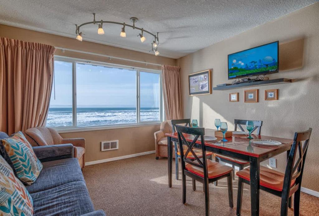 a living room with a table and a dining room at Top Floor Condo With Amazing Views Pool and Sauna in Lincoln City