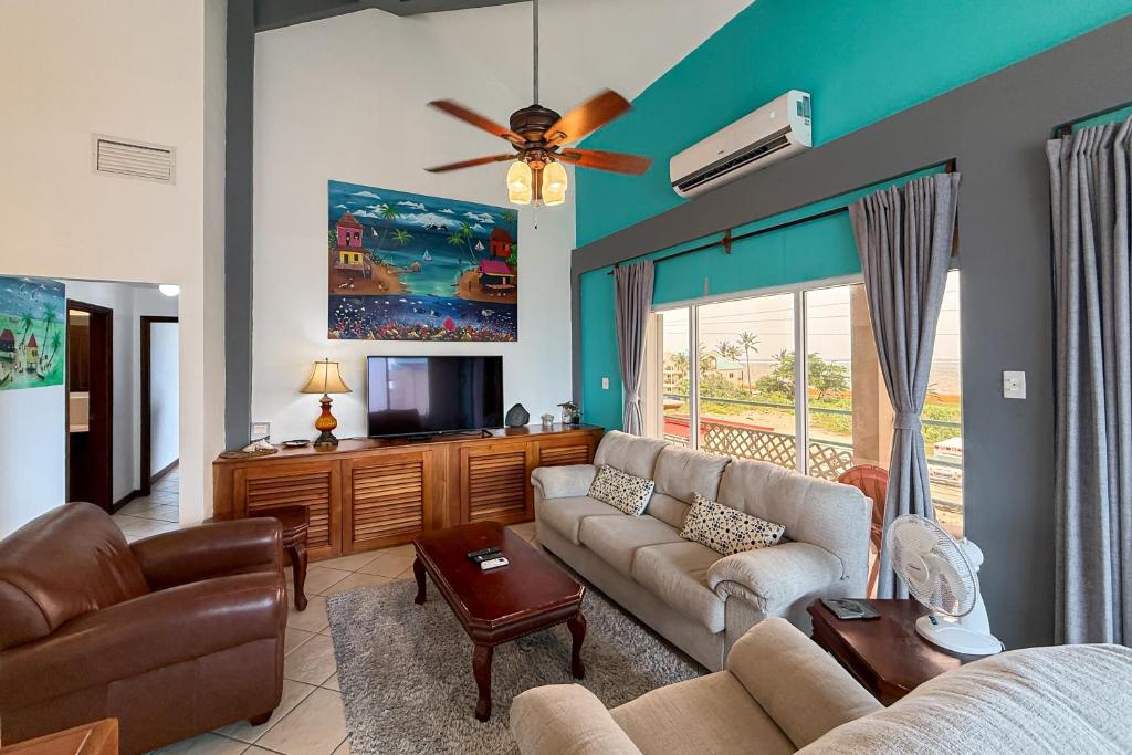 Una sala de estar con un sofá y un televisor. en Suite C303 Mara Laguna, en San Pedro