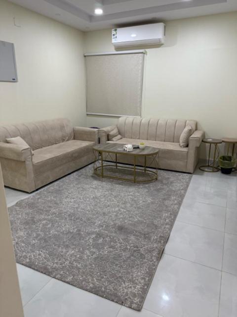 a living room with two couches and a table at شقة خالد المفروشة in Quai