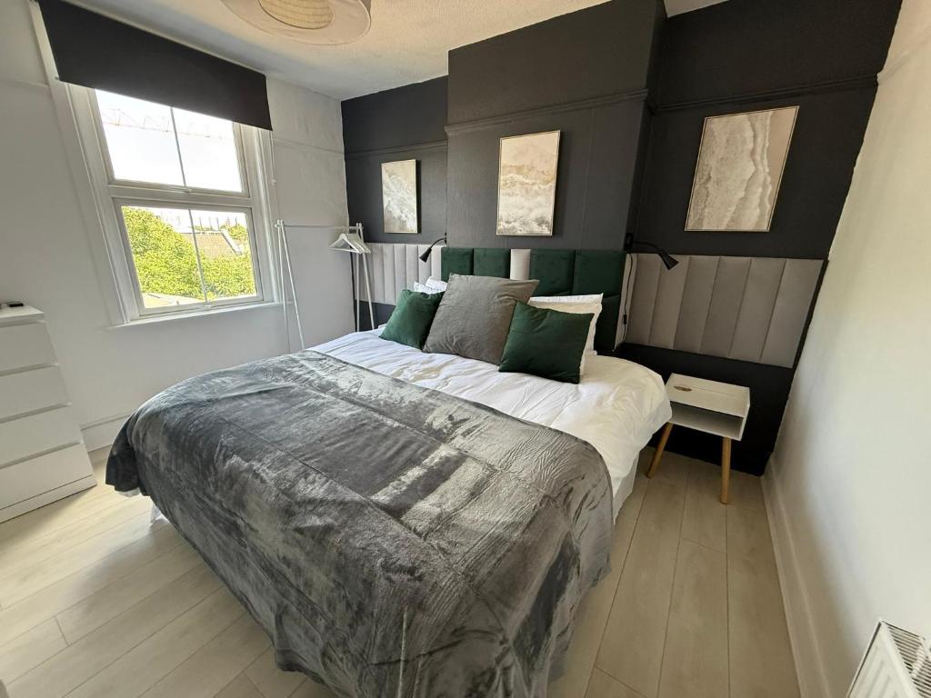 a bedroom with a large bed with green pillows at Abbey Wood Residence in Abbey Wood