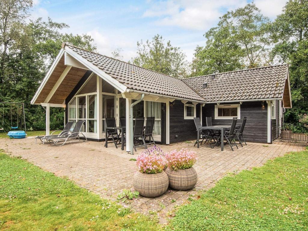 una casa con un patio con mesa y sillas en 7 person holiday home in Oksbøl, en Oksbøl
