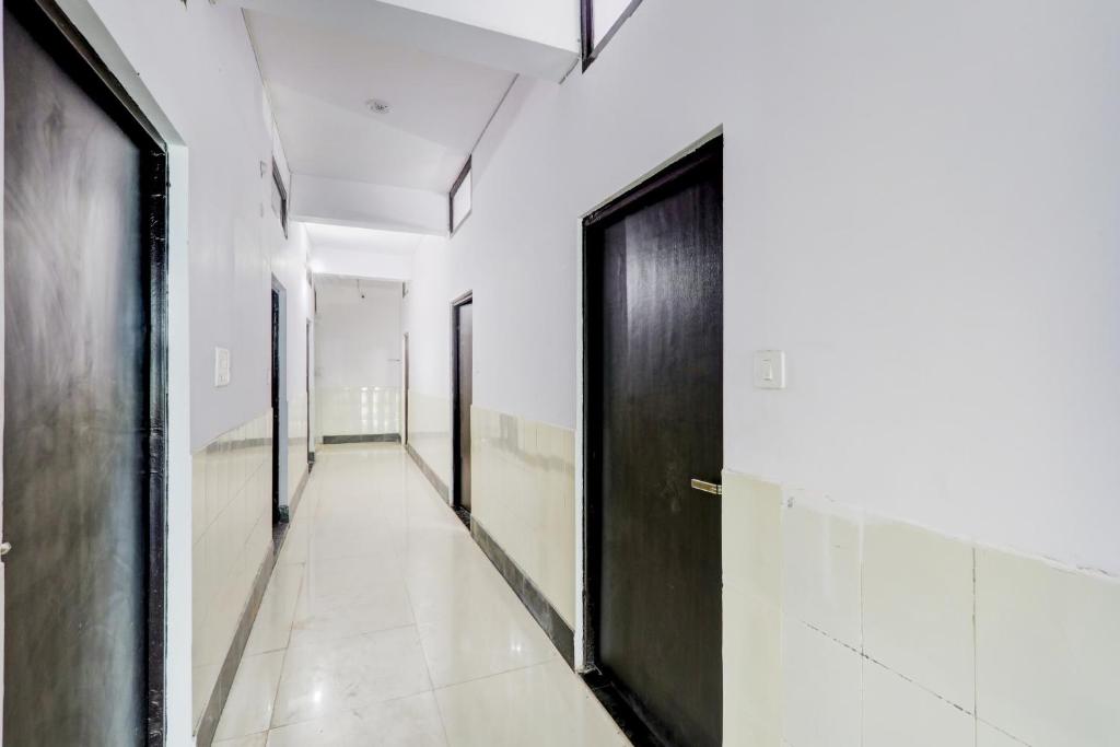 HasanganjHotel O SRV Palace的走廊设有黑色门和白色墙壁