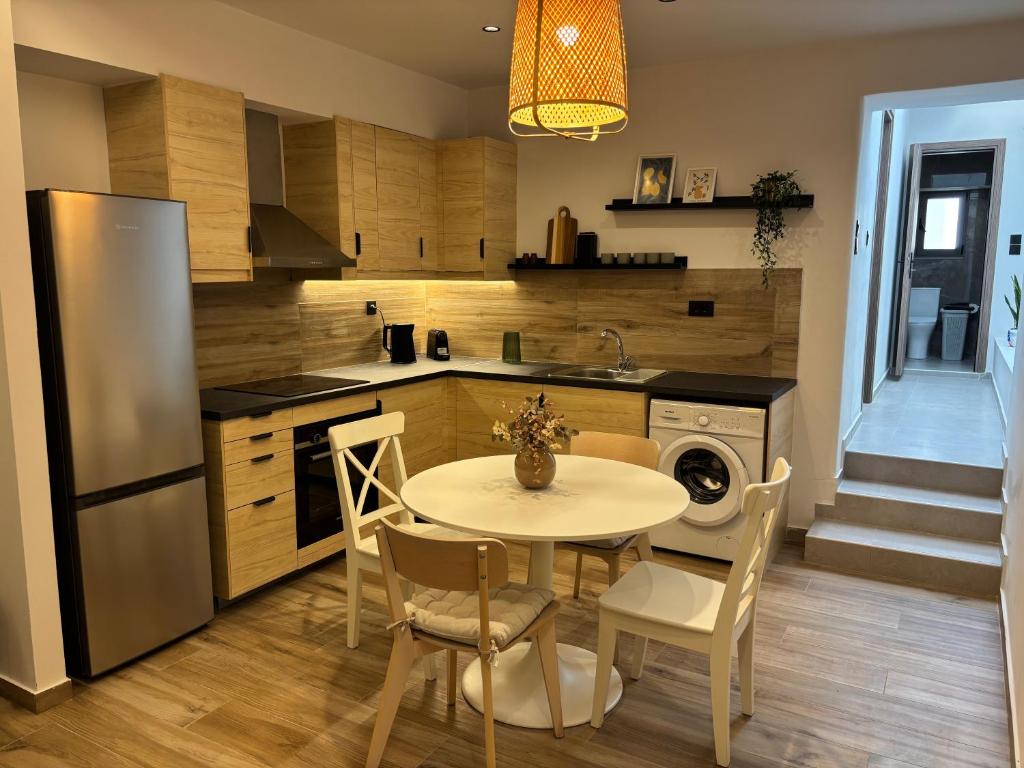 a kitchen with a table and chairs and a refrigerator at Sofia's Home in Chania Town