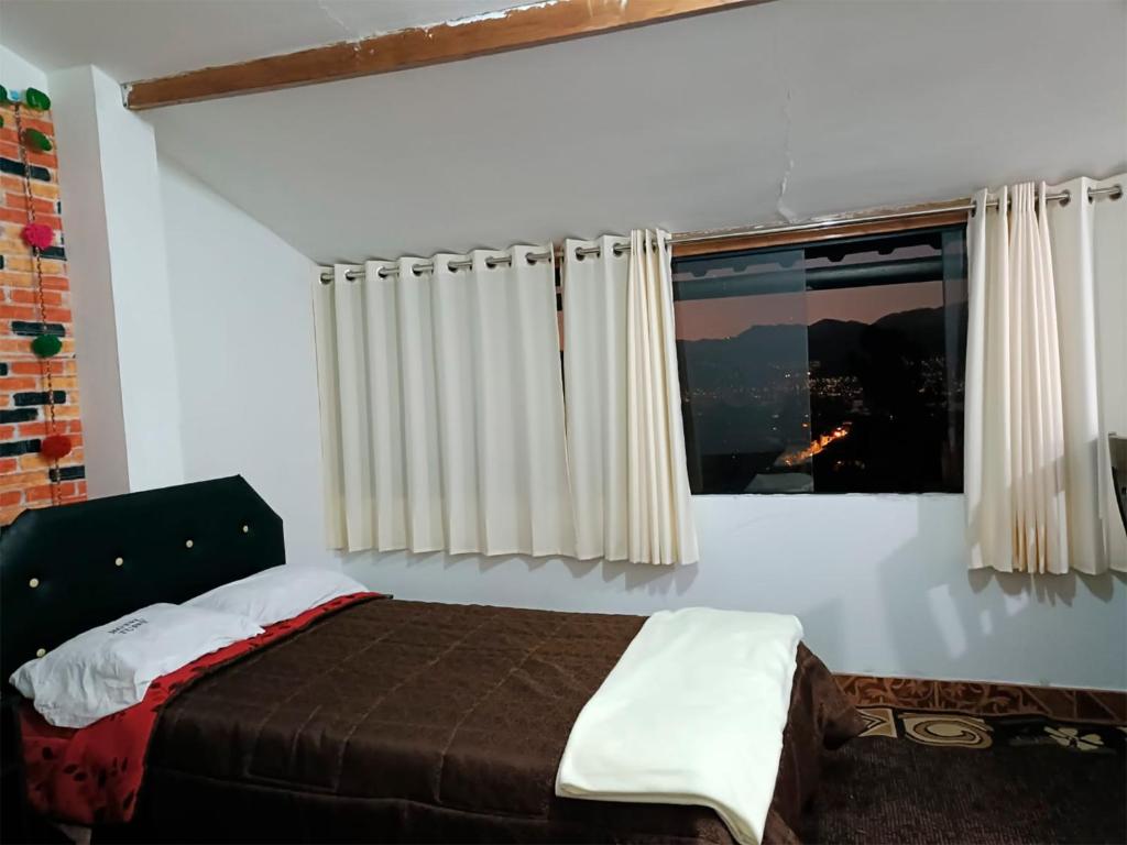 a bedroom with a bed and a window at 7 Borreguitos GUESTHOUSE in Cusco