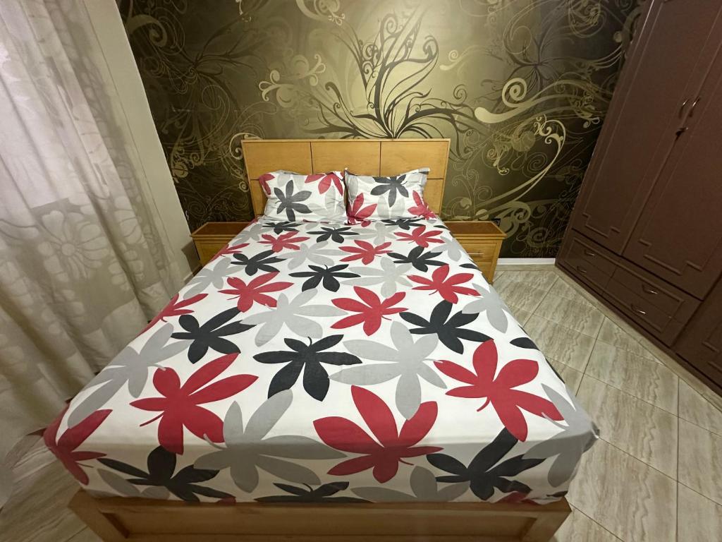 アガディールにあるChambre Cosy chez Redouanの花の咲く掛け布団付きのベッド(ベッドルーム内)