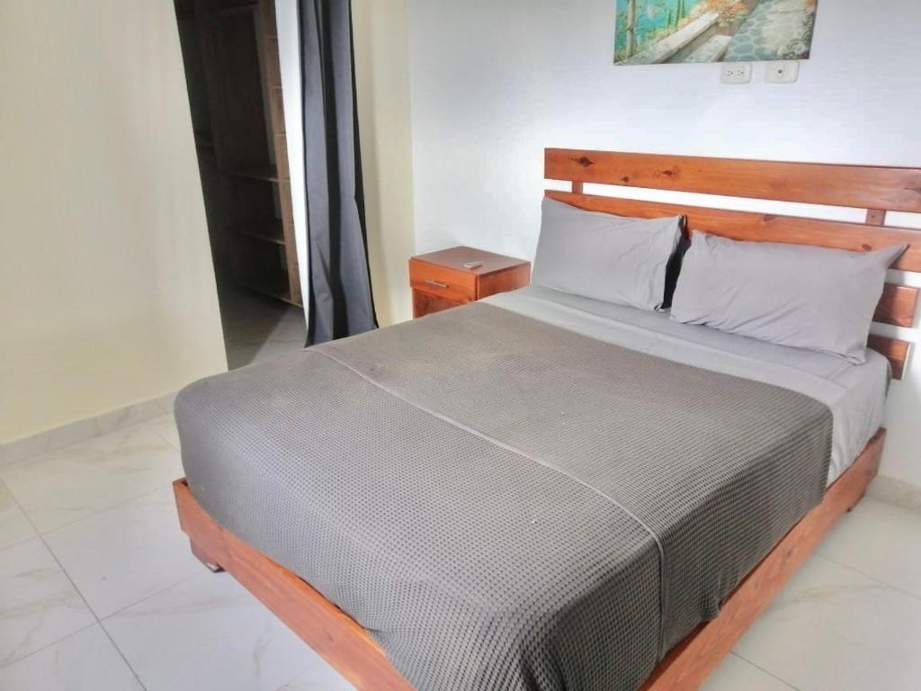 プンタ・カナにあるNice and Cozy Condo with Poolの木製のヘッドボードが付いた大きなベッドのある寝室