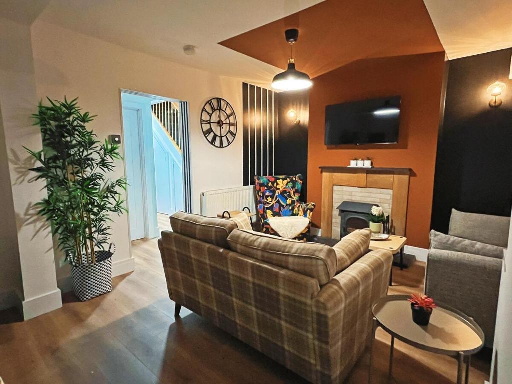 a living room with a couch and a fireplace at Darfield House Barnsley in Barnsley