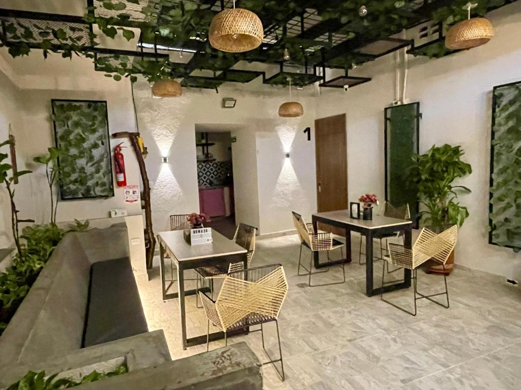 a room with two tables and chairs and potted plants at Nómada22 -Hostal moderno en el centro de Neiva in Neiva