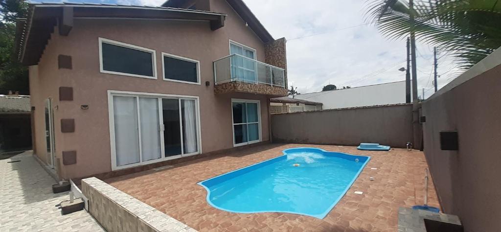 a swimming pool in front of a house at A Casa TOP da Região in Matinhos