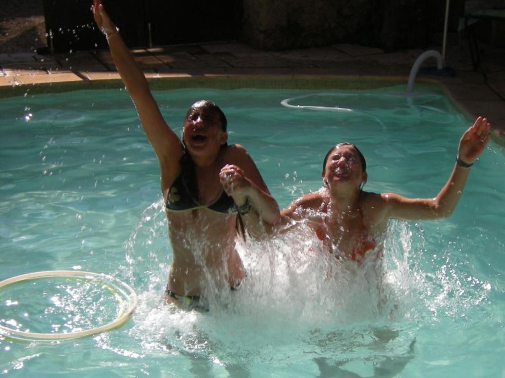 deux personnes jouent dans une piscine dans l'établissement Maison de Maitre Comfortable holiday residence, à Ferrals-lès-Corbières