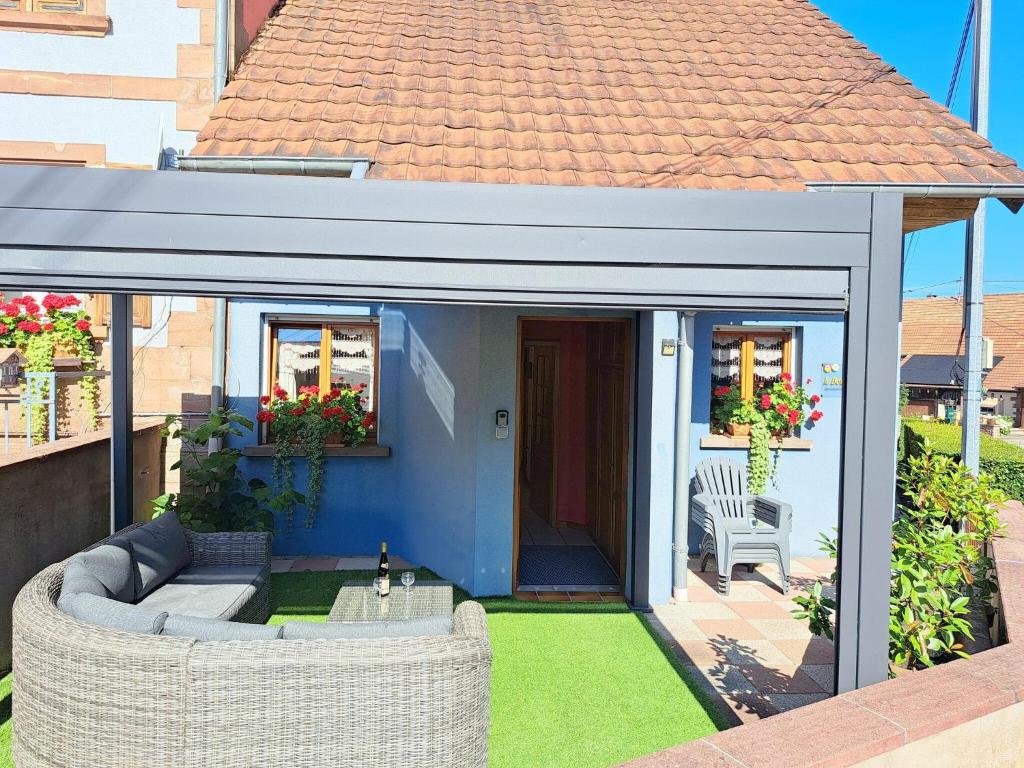 a covered patio with a couch and a chair at House near Vosges Park and La Petite Pierre in Hinsbourg