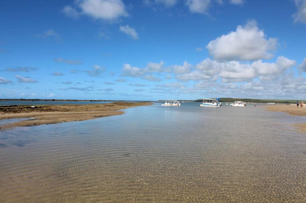 a group of boats in the water on a beach at ILOA Apto 02 quartos H in Barra de São Miguel
