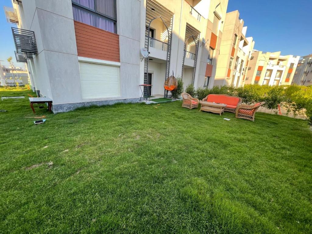 a yard with two benches and a building at Gaia - Ras Elhekma- Notth coast in Zāwiyat al ‘Awwāmah