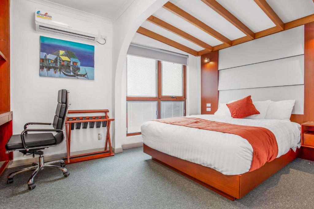 a bedroom with a bed and a desk and a chair at Oakleigh House in Burnie