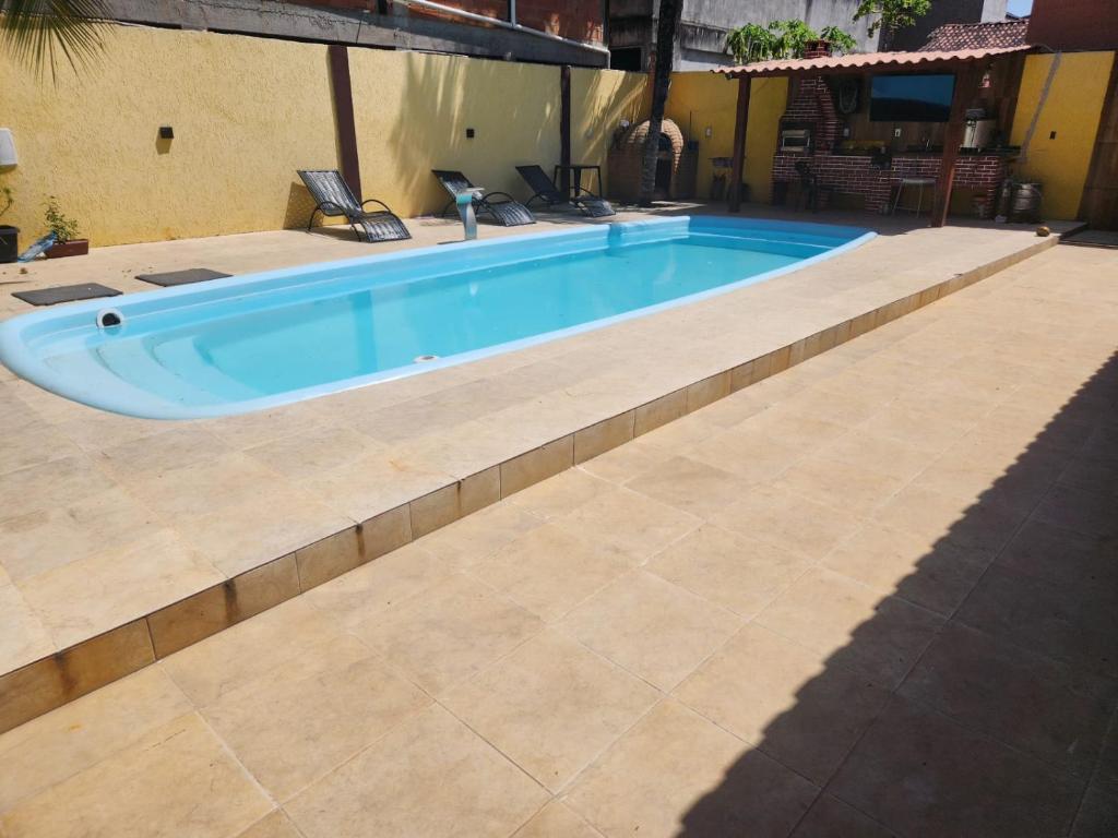 a swimming pool with a tile floor at Pousada Flor do Caribe in Rio das Ostras