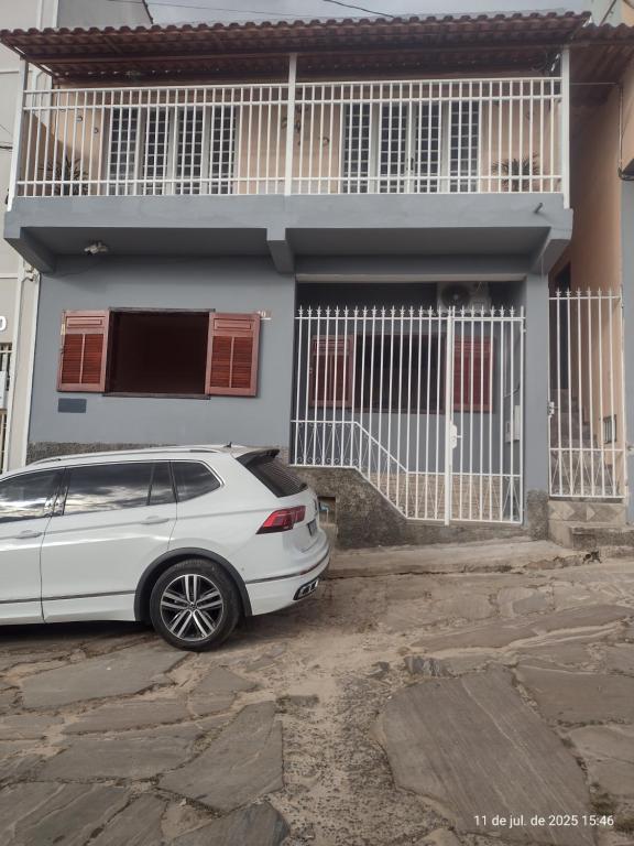 a white car parked in front of a house at Apartamento Avenida 10 com ar condicionado in São Thomé das Letras