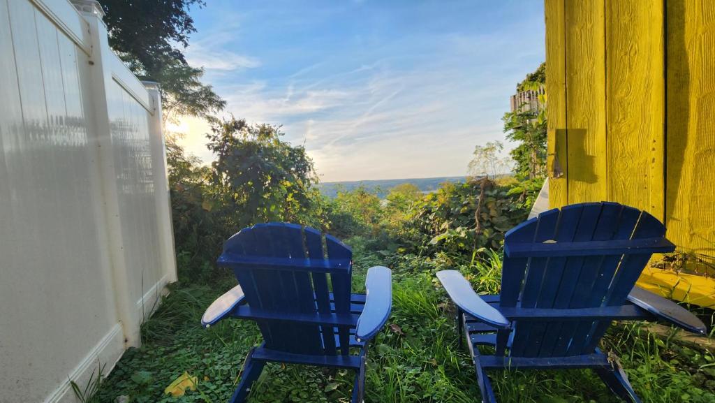two blue chairs sitting on the side of a house at The Seneca Sunset Suites in Burdett