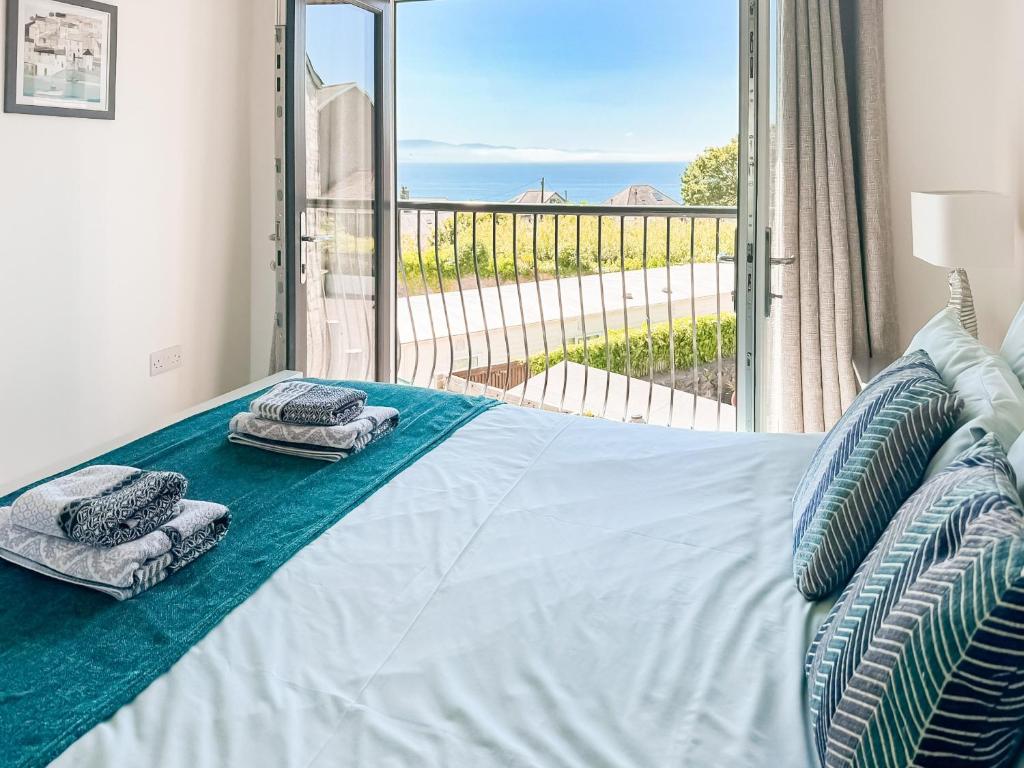 a bedroom with a bed with a view of the ocean at Trem Y Mor in Criccieth