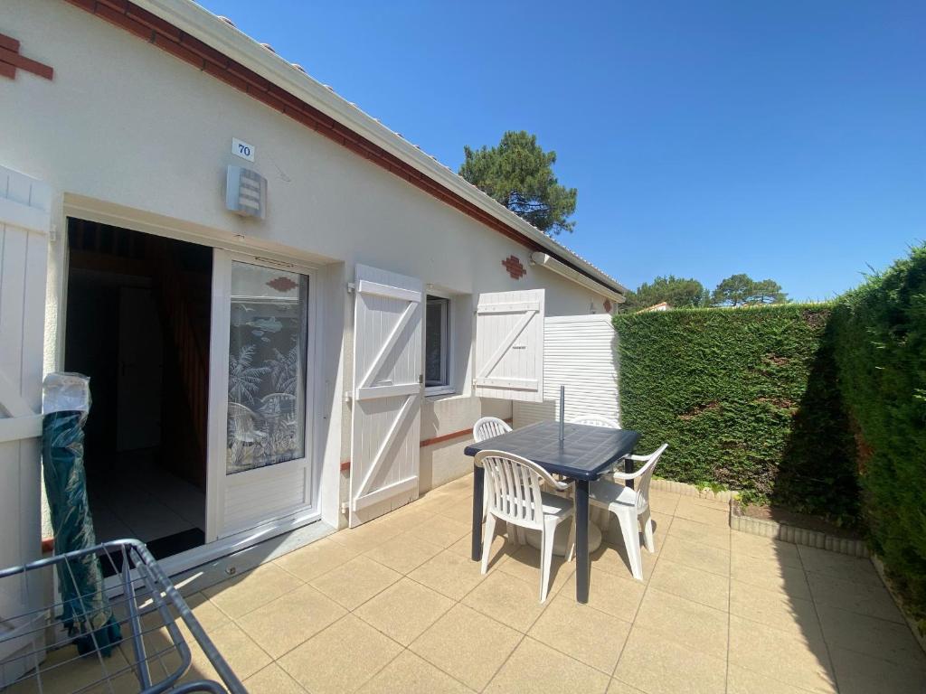 d'une terrasse avec une table et deux chaises. dans l'établissement Maison avec piscine proche plage, La Tranche-sur-Mer - FR-1-22-345, à La Tranche-sur-Mer