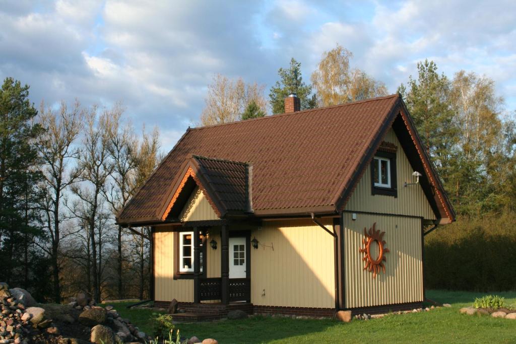 una pequeña casa con techo marrón en Vienkiemis prie Merkinės, en Merkinė