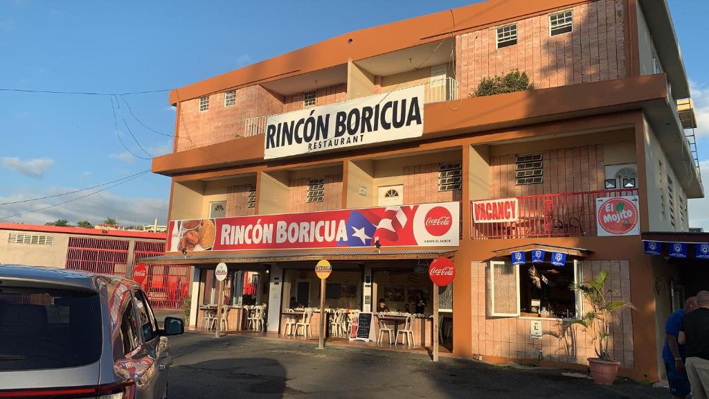 a building with a sign on the side of it at Rincon Boricua Apartments in Rincon