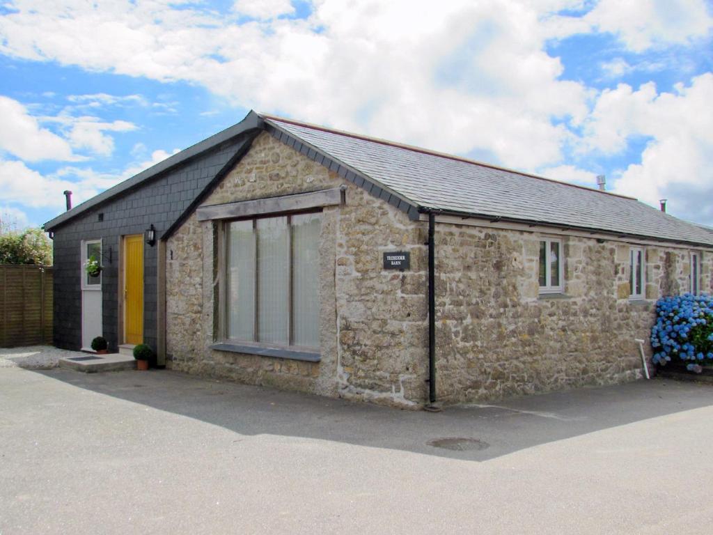 a stone building with a large window on it at Tresidder Barn in Constantine
