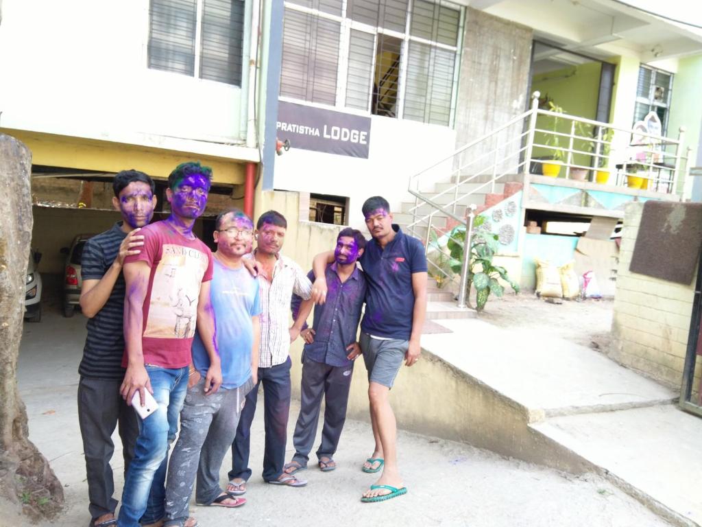 a group of men standing in front of a building at PRATISTHA Lodge in Guwahati