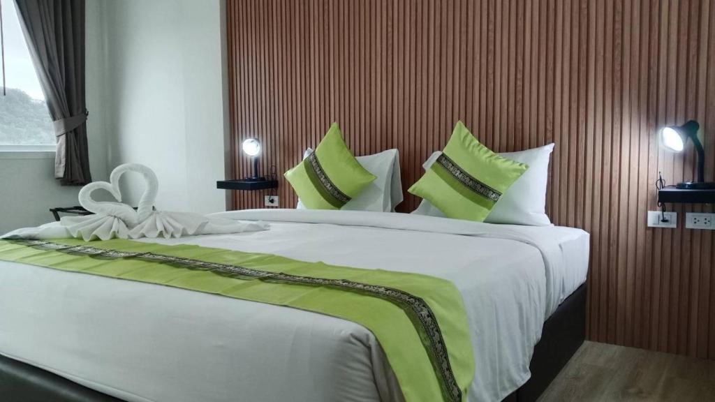 a bedroom with a large bed with green and white pillows at 28 Boutique Hotel - Newly Renovated in Patong Beach