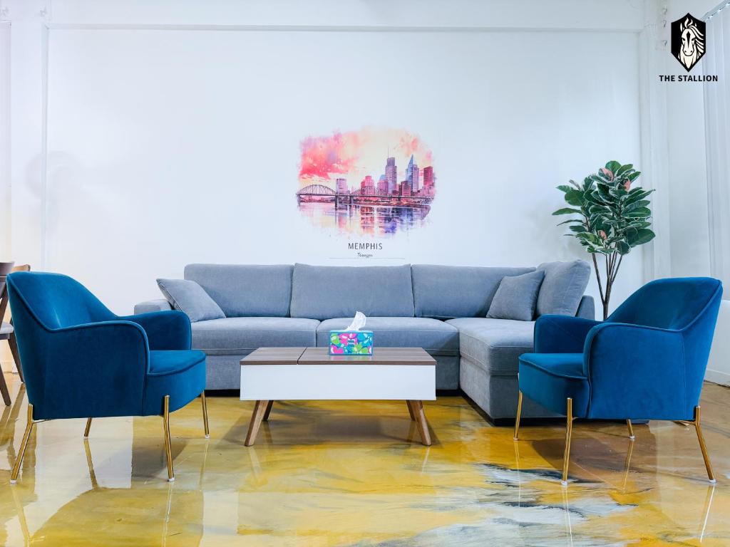 孟菲斯The Stallion #101 - 1BD Modern Loft with Private Patio - Walk to various attractions的客厅配有蓝色的沙发和两把椅子
